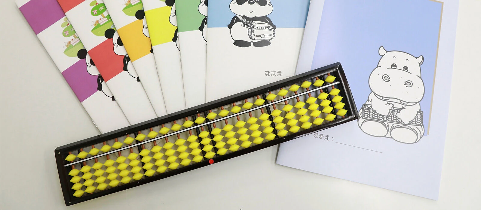黄色い珠のそろばんと、動物が描かれたピコの教材